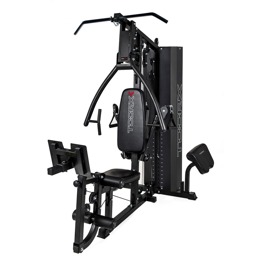 Pilnas jėgos staklių TOORX MSX-90 vaizdas iš priekio. Treniruoklis yra juodos spalvos, su įvairiais priedais ir svarmenų bloku kairėje pusėje.